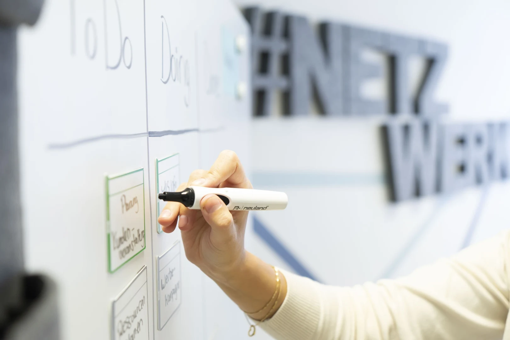 Hand, die auf ein Whiteboard schreibt