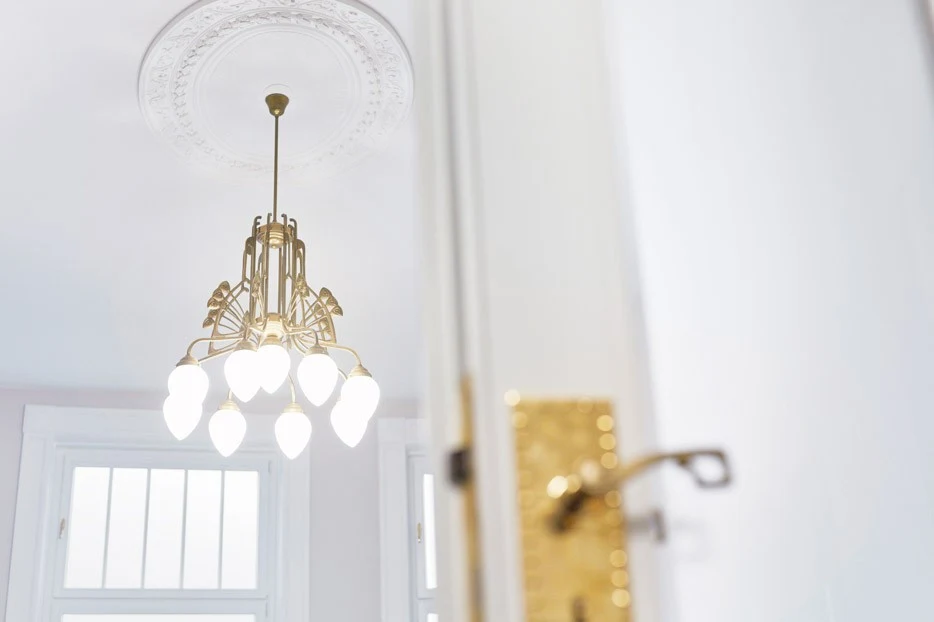 Kronleuchter, weiße Tür mit goldenem Türgriff